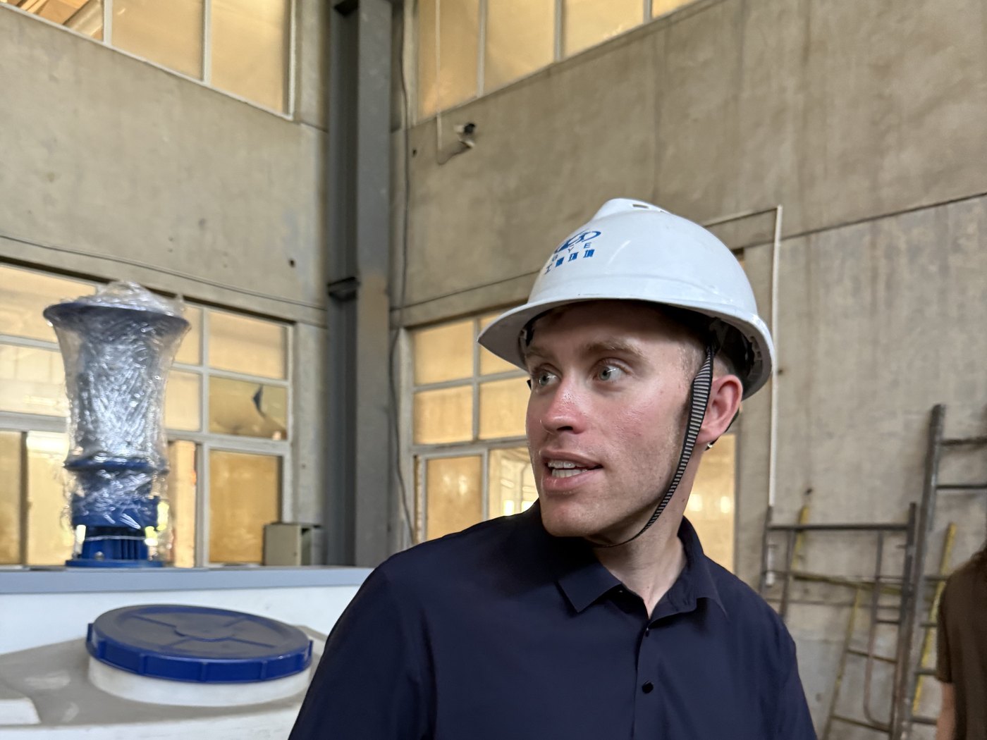 Spencer in a hard hat on a supplier's factory floor